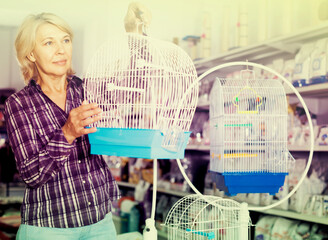 Portrait of mature woman purchasing bird cage in petshop