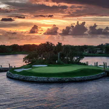a photo image of par 3 golf course adorned with an island green against sunset backgrouns.