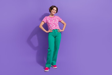 Full body photo of attractive young woman hands waist posing model wear trendy pink clothes isolated on purple color background