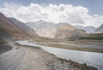 Pamir Highway dusty road in the mountains of Tajikistan early in the morning at dawn