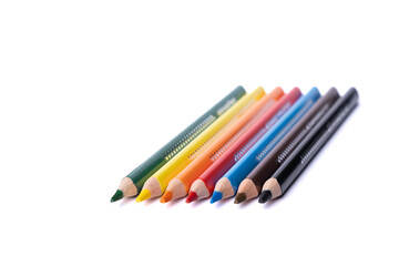 Buntstifte liegen in einer Reihe auf einem weißen Hintergrund 
