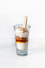 Detail of a snifter with a cream desert inside. Small glass with parfait as dessert.