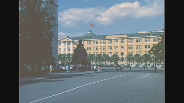Moscow, Russia - 1985: Tsar Bell in Ivanovskaya square with Kremlin Senate Palace with red Flag of the Soviet Union. Archival of Russia in the 1980s.