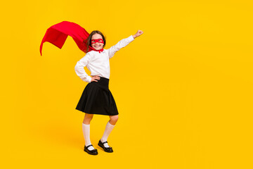 Full body photo of cute super girl raise fist empty space wear uniform isolated on yellow color background