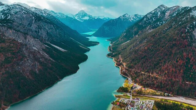 Aerial drone view Plansee lake among snow-capped mountains in Tyrolean Alps, Austria late autumn in cloudy weather. High quality 4k footage