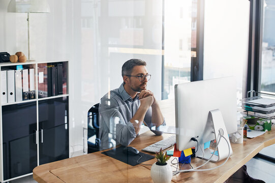 Office, thinking and business man on computer for online research, internet and news website. Corporate workspace, professional and person on pc for connection, reading email and planning at desk