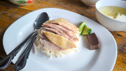 Hainanese chicken both steamed and fried chicken served with Hainanese oily rice, dipping sauces, and chicken clear soup. Thai famous Street food.