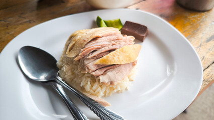 Hainanese chicken both steamed and fried chicken served with Hainanese oily rice, dipping sauces, and chicken clear soup. Thai famous Street food.