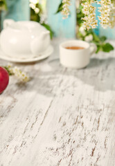 Summer Tea Party with Flowers and Sunlight on Wooden Background