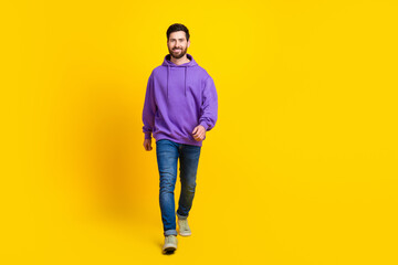 Naklejka premium Full size photo of handsome young guy walking model wear trendy violet outfit isolated on yellow color background