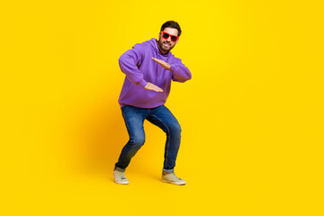 Full body photo of attractive young man sunglass cool dancing dressed stylish violet clothes isolated on yellow color background