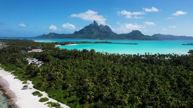 Aerial view of turquoise water and palm tree-lined Bora Bora Lagoon, Mount Otemanu, Vaitape, French Polynesia.