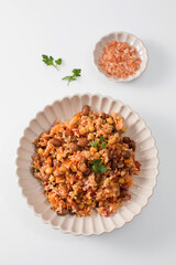 Jambalaya with rice chickpeas and kidney beans on white table