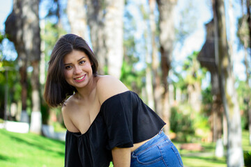 20s Hispanic woman, she is happy and smiling in the park. Carefree mood. 