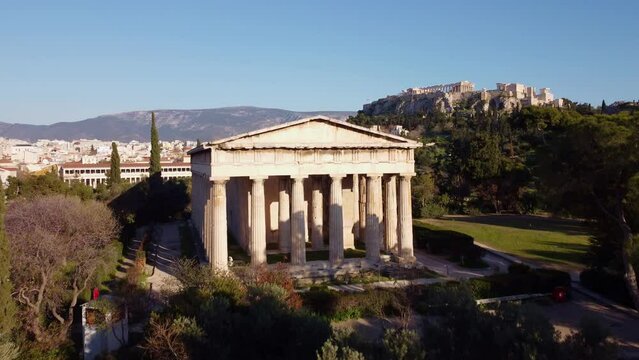 Temple of Hephaestus with the background of the city of Athens. Well-preserved artistic cultural heritage that attracts tourists in the summer period for a trip to discover the beauties of Greece.