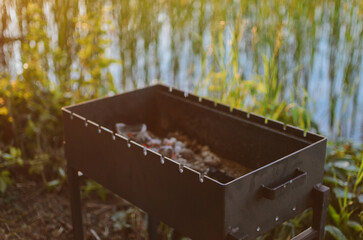 grill with hot coals for cooking grilled meat on the lake on a summer day in Estonia
