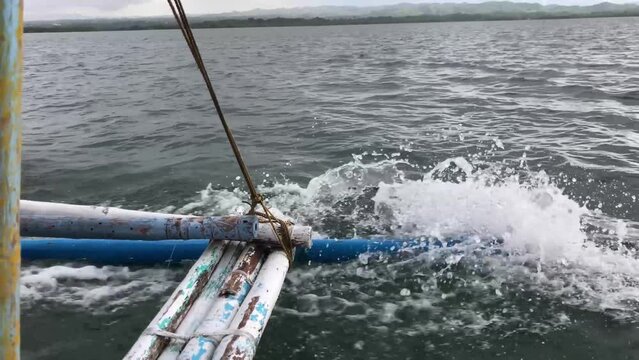 First-person view of the sea from a sailing boat whose outriggers banging against the waves