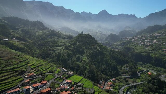 Aerial view of village nestled among terraced fields and lush greenery, Capelina de Nossa Senhora de Fatima, Sao Vicente, Madeira, Portugal.