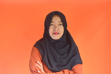 Portrait of an Asian Muslim woman in casual style on an isolated orange background