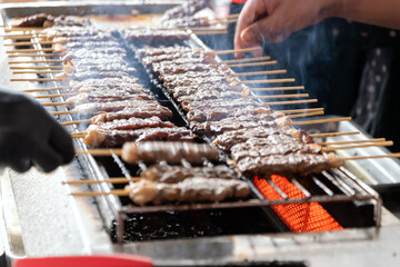 Delicious grilled skewers of beef on fire. Thai street food market.