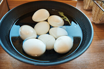 Whole boiled eggs in a black plate on a buffet table in a restaurant. Selective focus