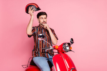 Portrait of young nice man wear shirt drive bike hold helmet think isolated on pink color background