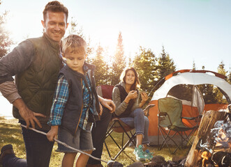 Family, camping and smores outdoor in forest for bonding with love, happiness and relax in nature with affection. Mother, father and son together for adventure in wilderness, peace and summer trip.