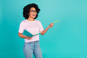 Photo portrait of lovely young lady write notebook look empty space dressed stylish striped garment isolated on aquamarine color background