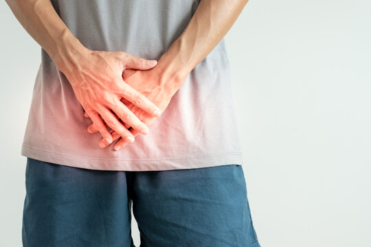 Man hold hand in front of private parts feeling discomfort from disease and inflammation. Venereal, testicular cancer. bladder problems, erectile dysfunction, premature ejaculation, prostate cancer.