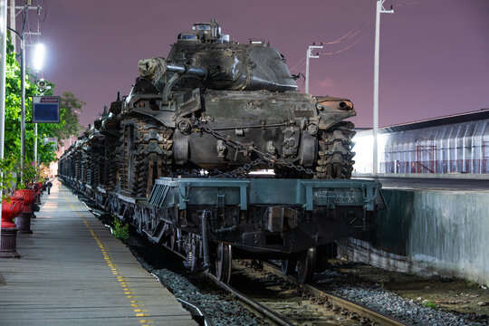 Cargo train carrying military tanks on railway flat wagons - Powered by Adobe