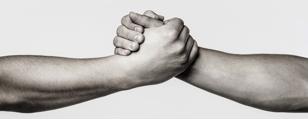 Handshake, arms, friendship. Friendly handshake, friends greeting, teamwork friendship. Rescue, helping gesture or hands. Strong hold. Close-up. Two hands, helping hand of a friend. Black and white