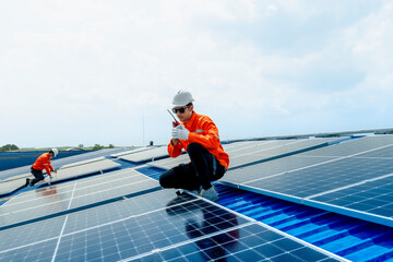 engineer man inspects construction of solar cell panel or photovoltaic cell by electronic device. Industrial Renewable energy of green power. factory worker working on tower roof.