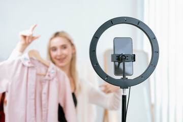 Young social medial content creator woman make fashion video. Blogger smiles to camera and light...