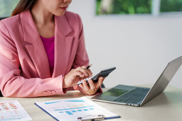 40-year-old middle-aged Asian businesswoman wearing pink suit, business finance, investment strategies, risk management. Skilled in planning, analysis, operations control for business success.
