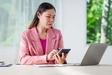 40-year-old middle-aged Asian businesswoman wearing pink suit, business finance, investment strategies, risk management. Skilled in planning, analysis, operations control for business success.