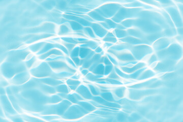 Blue water with ripples on the surface. Defocus blurred transparent blue colored clear calm water surface texture with splashes and bubbles. Water waves with shining pattern texture background.