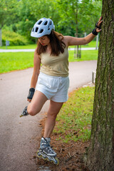 Roller skater woman warming up in park before rollerblading on inline skates. Outdoor activities....
