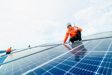 engineer man inspects construction of solar cell panel or photovoltaic cell by electronic device. Industrial Renewable energy of green power. factory worker working on tower roof.