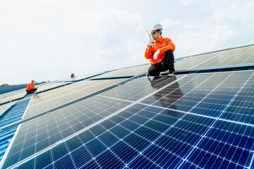 engineer man inspects construction of solar cell panel or photovoltaic cell by electronic device. Industrial Renewable energy of green power. factory worker working on tower roof.