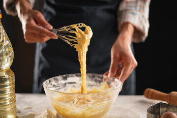 Whisking dough mixture in bowl during baking preparation, close-up