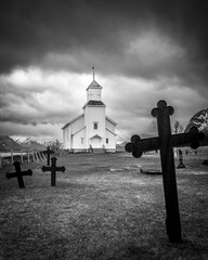 A Moody Black and White Image of a Small Church with Grave Markers