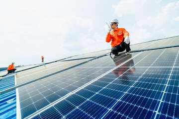 engineer man inspects construction of solar cell panel or photovoltaic cell by electronic device. Industrial Renewable energy of green power. factory worker working on tower roof.