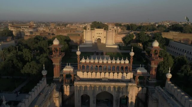 Aerial view of Badshahi Mosque with fort, trees, garden, courtyard, walls, towers, and entrance, Lahore, Punjab, Pakistan.