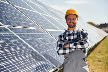 Cheerful engineer with photovoltaic solar panels outdoors at daytime