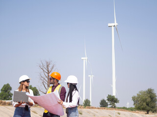 A group of engineers and architects are consulting. About taking care of wind turbines For a sustainable environment