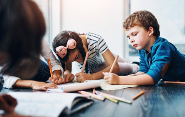 Drawing, color and children on floor with paper for creative lesson, learning and child development at kindergarten. School, youth academy and kids with crayons for education, creativity and writing