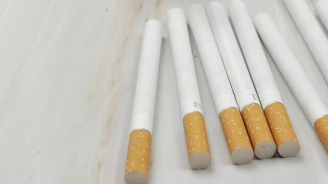 plusieurs cigarettes, en gros plan, &eacute;tal&eacute;es sur une table