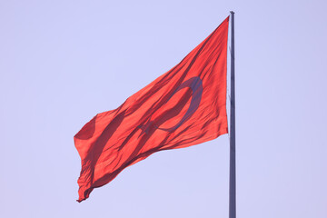 Turkish flag, on a red background white star and moon. Turkish flag flies in the wind against the backdrop of Istanbul