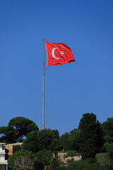 Turkish flag, on a red background white star and moon. Turkish flag flies in the wind against the backdrop of Istanbul