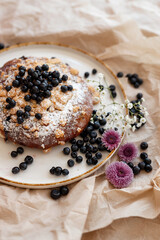 Delicious pastry dusted with powdered sugar and adorned with fresh blackberries on a berry background